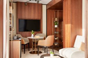 a living room with a television and a table at Thompson Madrid, by Hyatt in Madrid