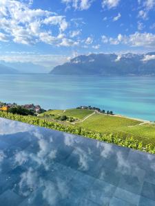 a pool with a view of the water and mountains at Baron Tavernier Hotel Restaurant & SPA in Chexbres