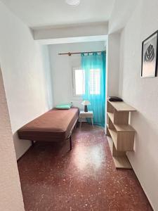 Habitación pequeña con cama y ventana en piso en zapillo, en Almería