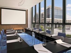 a conference room with tables and chairs and a large window at Mercure Dubai Deira in Dubai