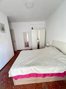 1 dormitorio blanco con 1 cama grande con sábanas rosas en piso en zapillo, en Almería