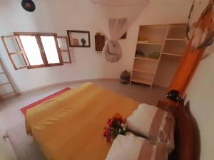 萨利尼亚拉尔Cosy Case avec son Jaccuzi privé Saly的一间卧室,床上放着鲜花