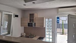 a kitchen with a sink and a microwave at Apartment for 6 people with parking near beach Trstenik in Split