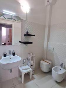 une salle de bain blanche avec un lavabo et des toilettes dans l'établissement Casa Giulia, à LʼAquila 10 autres photos