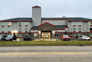 a large building with cars parked in front of it at Howard Johnson by Wyndham Urbana in Champaign