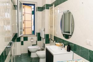 bagno con lavandino, servizi igienici e specchio di Divina suite Cavaliere a Maiori