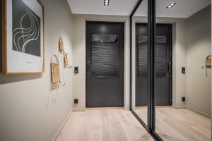 a hallway with black doors and wooden floors at Luxurious Hideaway in Centrum in Bergen