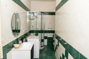 a green and white bathroom with a shower and a sink at Divina suite Cavaliere in Maiori