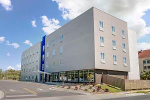 a large white building on the side of a street at Sleep Inn & Suites Fort Walton Beach - Destin West in Fort Walton Beach