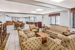 a waiting room with couches and tables and a cafeteria at Express Inn in Champaign