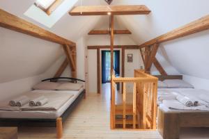 a attic room with two beds and a staircase at Vila Jana in Radovljica