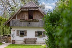 una pequeña casa con un banco delante en Vila Jana en Radovljica