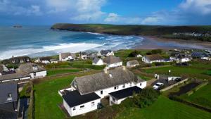 an aerial view of a houses and the ocean at Trequite - 5 Bedroom clifftop home with sea views in Polzeath
