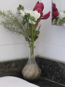 a vase with flowers in it sitting on a counter at Golden Hill Parker Hotel in Elmina