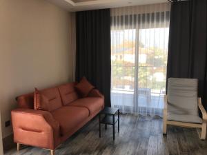een woonkamer met een bank en een groot raam bij Tanem Suit in Antalya