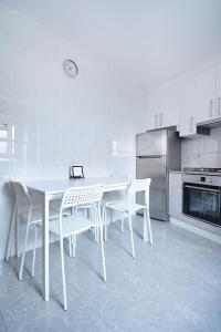 cocina con mesa blanca y sillas blancas en Casa en Muros con preciosas vistas al mar, en Muros
