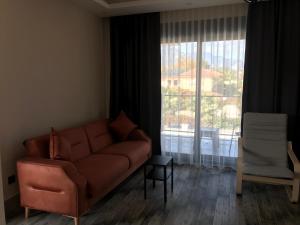 een woonkamer met een bank en een groot raam bij Tanem Suit in Antalya