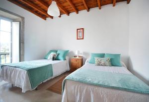dos camas sentadas una al lado de la otra en un dormitorio en Casa en Muros con preciosas vistas al mar, en Muros