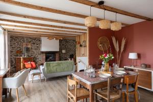 a living room with a wooden table and chairs at La Buissonnière - Maison à 5 min des plages in Le Minihic-sur-Rance