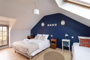 sypialnia z dużym łóżkiem i niebieską ścianą w obiekcie La Buissonnière - Maison à 5 min des plages w mieście Le Minihic-sur-Rance