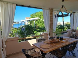 a dining room with a table and a large window at Seaview Holiday Home GATSBY in Petrcane