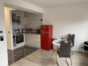 uma cozinha com um frigorífico vermelho e uma mesa em Holiday apartment Siuerlänner em Langscheid