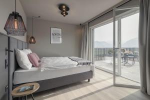 a bedroom with a bed and a balcony at Belia Lofts - ADULTS ONLY - Apartments in Appiano sulla Strada del Vino