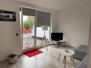 un soggiorno con divano, tavolo e TV di Holiday apartment Siuerlänner a Langscheid