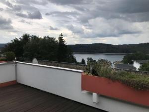 uma varanda com vista para um corpo de água em Holiday apartment Siuerlänner em Langscheid
