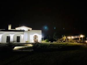 una casa bianca di notte con le luci accese di Villa Elia - Tenuta Le Scerze - Salento Homes a Borgagne
