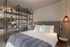 Un dormitorio con una gran cama blanca y estanterías en Belia Lofts - ADULTS ONLY, en Appiano sulla Strada del Vino