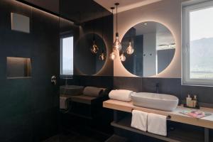 a bathroom with a sink and a mirror at Belia Lofts - ADULTS ONLY - Apartments in Appiano sulla Strada del Vino