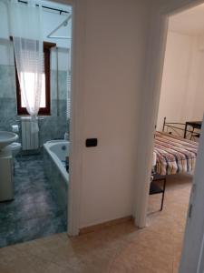 uma casa de banho com uma banheira, um lavatório e uma cama em FERRARO ALLOGGIO TURISTICO em Ladispoli