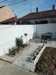 a patio with a table and some plants on it at Gostinska kuća in Leskovac +27 photos