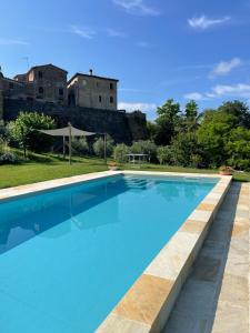 a swimming pool with a castle in the background at Dimora nel Castello di Loretello in Loretello