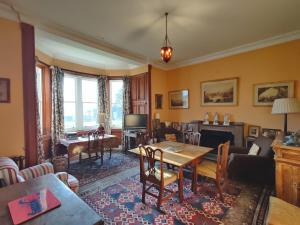 Torloisk House في Kilninian: غرفة معيشة مع طاولة وتلفزيون