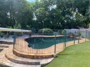 una valla alrededor de una piscina en un patio en Pristine 1 Bed Cottage in Northern suburbs - 2222 en Kingsmead