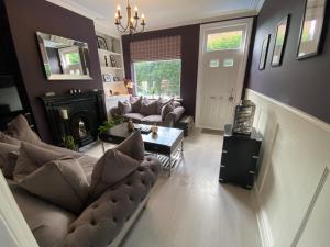 een woonkamer met een bank en een open haard bij Interior Designed 4 bed Home Horsforth with gym! in Horsforth