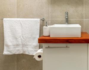 a bathroom with a sink and a white towel at Kamuzi exquisite tiny home near airport - 2217 in Harare