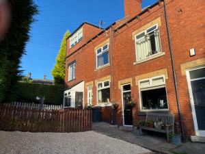 a brick house with a fence in front of it at Interior Designed 4 bed Home Horsforth with gym! in Horsforth