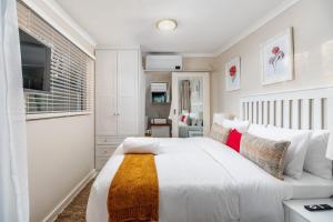 ハラレにあるKamuzi exquisite tiny home near airport - 2217の白いベッドルーム(大型ベッド1台、テレビ付)
