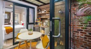 una habitación con mesa y sillas y un dormitorio en Kamuzi exquisite tiny home near airport - 2217 en Harare