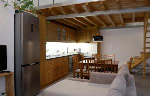 een keuken en eetkamer met een roestvrijstalen koelkast bij Cane’s Family Guest House in Plomarion