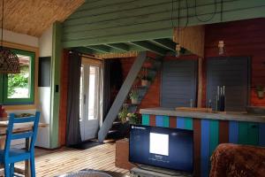 uma sala de estar com televisão e uma casa em Balistyle guesthouse near Schiphol (and Amsterdam) em Vijfhuizen