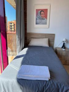 a bed with a blue blanket on top of it at APARTAM GRANOLLERS in Granollers