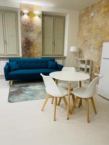 - un salon avec un canapé bleu, une table et des chaises dans l'établissement Residenza Piaz. San Michele Incanto, à Arezzo