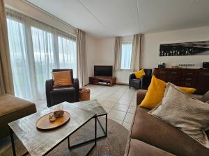 a living room with a couch and a table at Kustverhuur, Park Scheldeveste Zwin 065 in Breskens