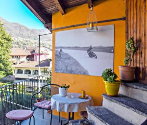 patio con tavolo e foto di un uomo su una moto di Antica Officina a Mandello del Lario