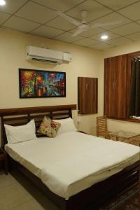 una camera con un grande letto bianco e un ventilatore di Maharaja Hotel and Restaurant a Ratia