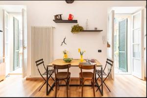 Un comedor con mesa y sillas de madera. en Piazza Volta Apartment, en Como